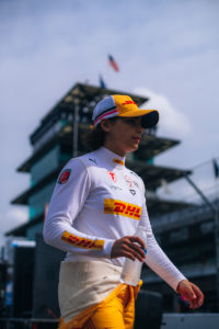 Photo of Race car driver Jamie Chadwick walking in the pits at the INDY by Firestone NXT GP